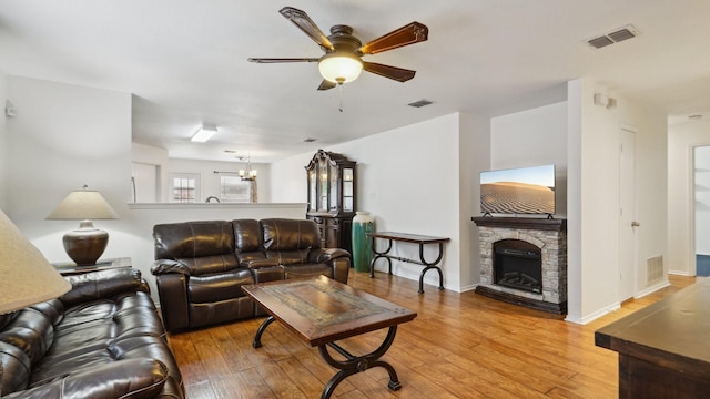 12712 Feathering Dr, Frisco, TX 75036 - living area featuring ceiling fan, light wood finished floors, a stone fireplace, and baseboards