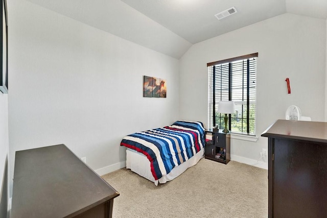 carpeted bedroom with vaulted ceiling and baseboards