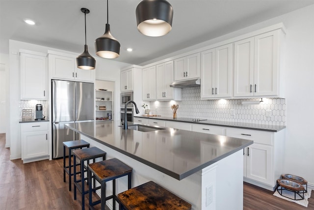 1420 Escondido Dr, Fort Worth, TX 76052 - kitchen with stainless steel appliances, a sink, dark countertops, a kitchen bar, and dark wood-type flooring