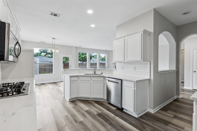 kitchen featuring appliances with stainless steel finishes, dark wood-type flooring, white cabinetry, a peninsula, and recessed lighting