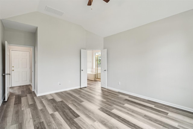 unfurnished bedroom with vaulted ceiling, wood finished floors, baseboards, ensuite bath, and a ceiling fan