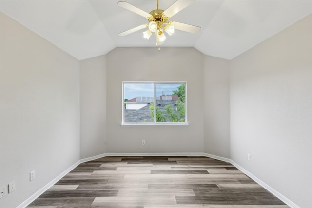 unfurnished room with a ceiling fan, wood finished floors, vaulted ceiling, and baseboards