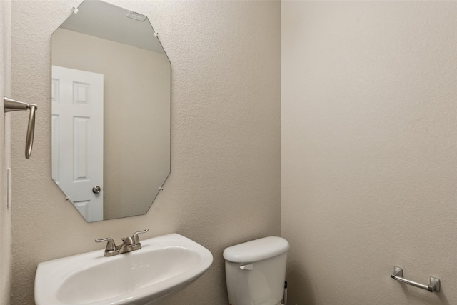 half bath featuring a sink and toilet