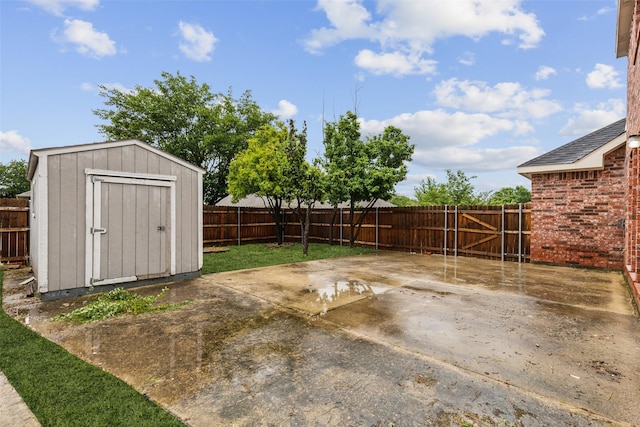 fenced backyard featuring a patio area, a storage unit, and an outbuilding