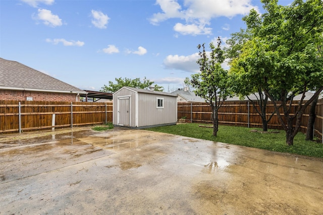 view of patio featuring an outbuilding, a fenced backyard, and a storage unit