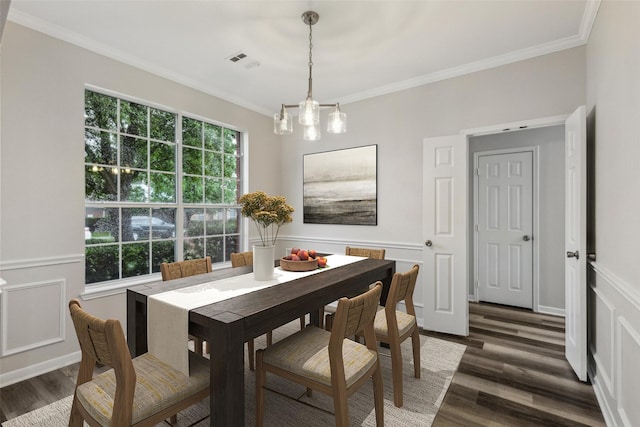 dining area featuring wood finished floors, ornamental molding, and a chandelier