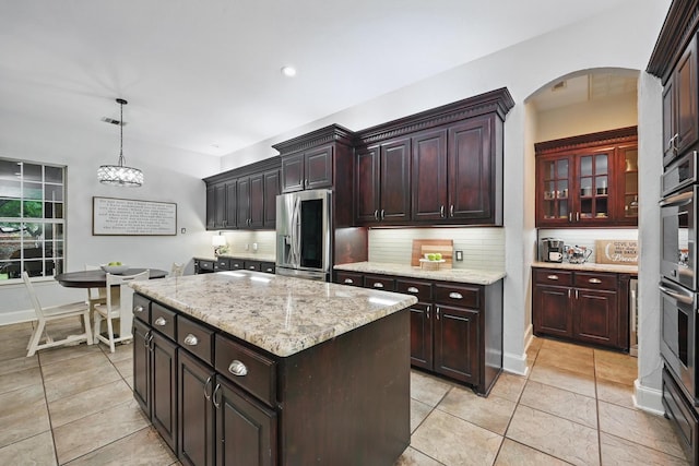 2099 Remington Ln, Frisco, TX 75033 - kitchen with appliances with stainless steel finishes, arched walkways, backsplash, light tile patterned floors, and recessed lighting