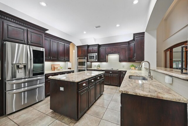 2099 Remington Ln, Frisco, TX 75033 - kitchen featuring stainless steel appliances, a sink, arched walkways, decorative backsplash, and recessed lighting