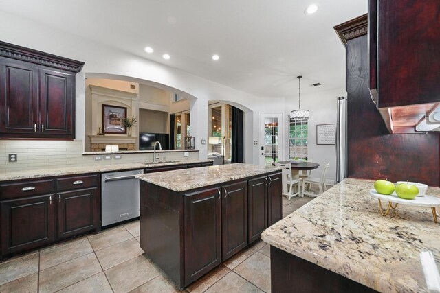 2099 Remington Ln, Frisco, TX 75033 - kitchen featuring dishwasher, a kitchen island, decorative backsplash, arched walkways, and light tile patterned flooring