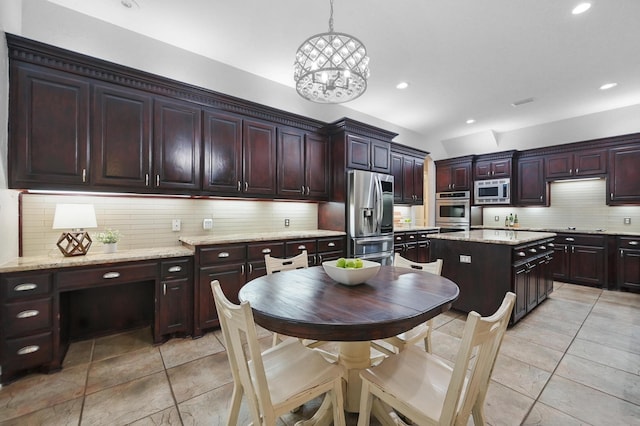 2099 Remington Ln, Frisco, TX 75033 - kitchen featuring appliances with stainless steel finishes, tasteful backsplash, light tile patterned flooring, recessed lighting, and pendant lighting