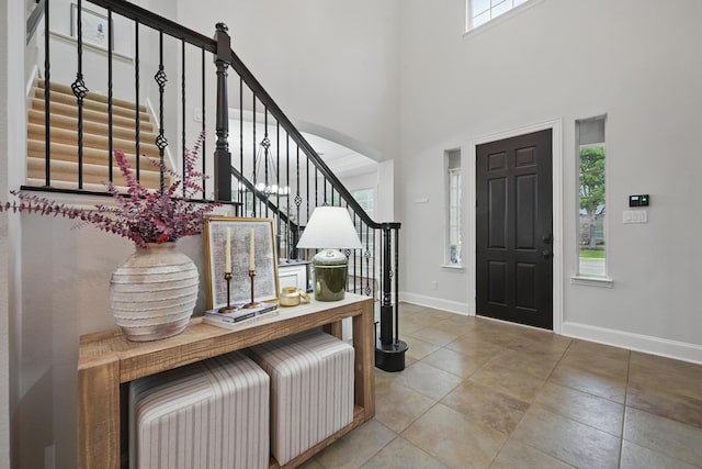 2099 Remington Ln, Frisco, TX 75033 - tiled entrance foyer with stairs, plenty of natural light, baseboards, a high ceiling, and arched walkways