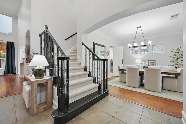 2099 Remington Ln, Frisco, TX 75033 - staircase with arched walkways, tile patterned floors, healthy amount of natural light, crown molding, and a high ceiling