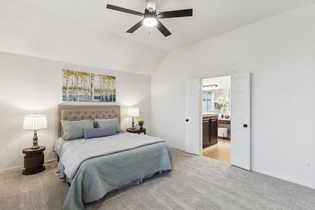 bedroom featuring light carpet, vaulted ceiling, connected bathroom, baseboards, and ceiling fan