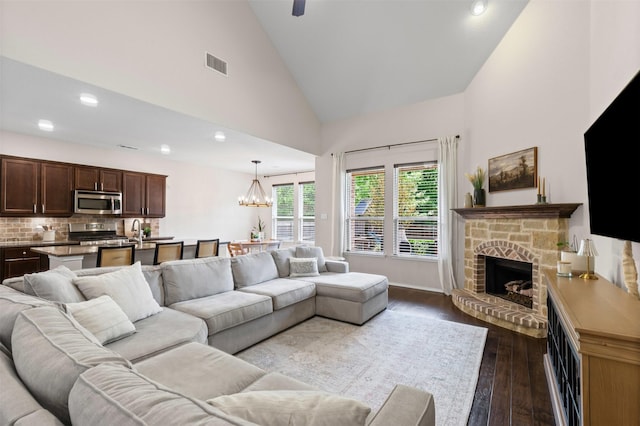 1744 Wildflower Ln, Wylie, TX 75098 - living room featuring dark wood-style flooring, a fireplace, a chandelier, recessed lighting, and high vaulted ceiling