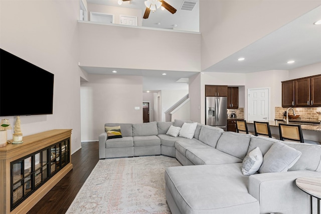 1744 Wildflower Ln, Wylie, TX 75098 - living room with a ceiling fan, dark wood-style flooring, a towering ceiling, recessed lighting, and baseboards