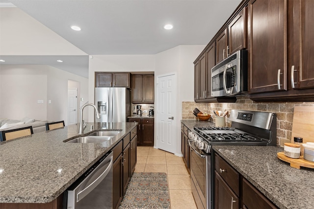 1744 Wildflower Ln, Wylie, TX 75098 - kitchen with appliances with stainless steel finishes, a sink, dark stone countertops, tasteful backsplash, and recessed lighting