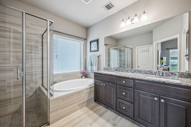 full bath with a shower stall, double vanity, and a bath