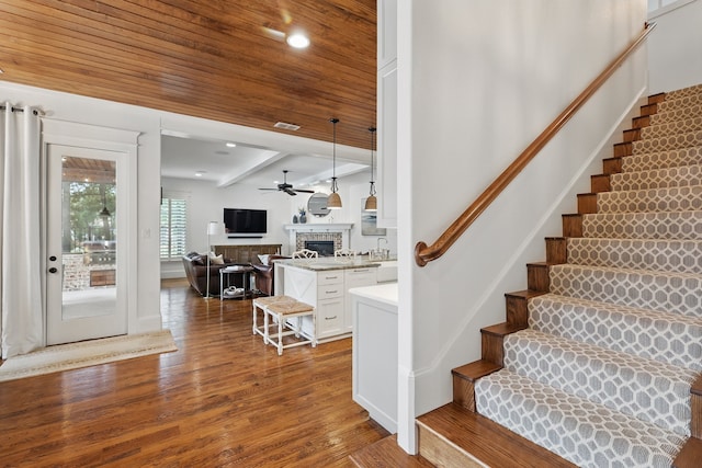 304 Nora Ln, Argyle, TX 76226 - stairs with a fireplace, wood finished floors, a ceiling fan, and beam ceiling