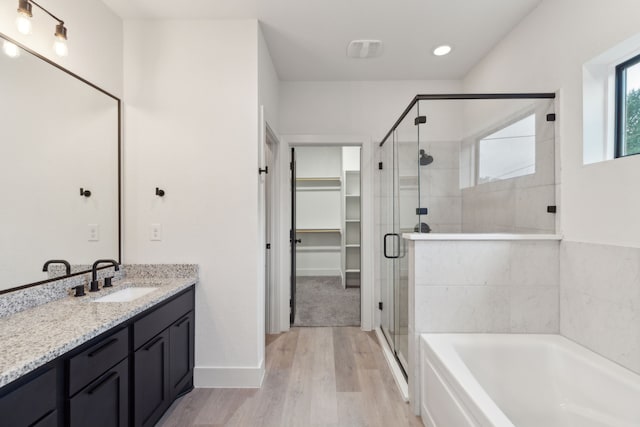 1967 Bayside St, Dallas, TX 75212 - bathroom with a garden tub, a stall shower, vanity, a spacious closet, and recessed lighting