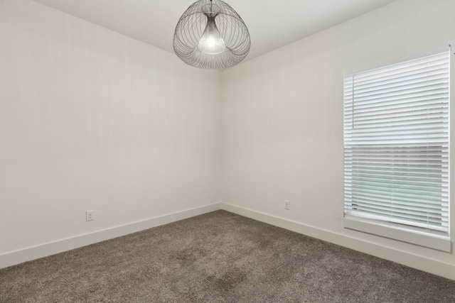 1967 Bayside St, Dallas, TX 75212 - empty room with dark carpet, baseboards, and a chandelier