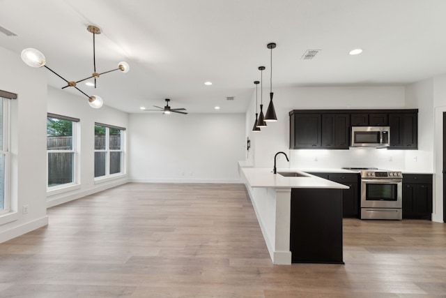 1967 Bayside St, Dallas, TX 75212 - kitchen with appliances with stainless steel finishes, a sink, dark cabinets, recessed lighting, and a chandelier