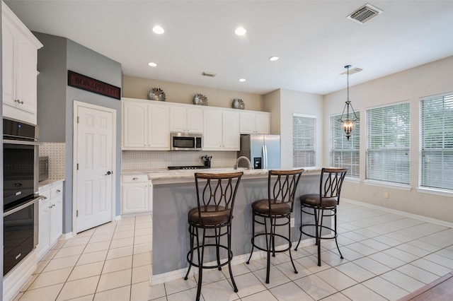 2713 Pasadena Pl, Flower Mound, TX 75022 - kitchen featuring stainless steel appliances, backsplash, white cabinets, a kitchen bar, and recessed lighting