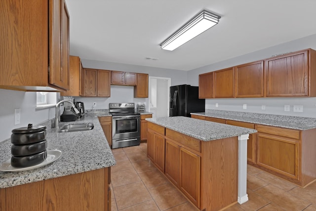 3503 Ridge Crossing Dr, Dallas, TX 75227 - kitchen with stainless steel electric stove, a sink, black fridge, a kitchen island, and light tile patterned floors