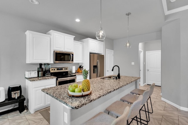 306 N Pendell Ave, Cleburne, TX 76033 - kitchen featuring stainless steel appliances, a sink, light stone countertops, white cabinetry, and a kitchen island with sink