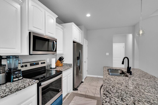 306 N Pendell Ave, Cleburne, TX 76033 - kitchen with stainless steel appliances, a sink, light stone countertops, white cabinets, and recessed lighting