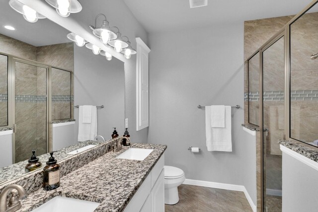 306 N Pendell Ave, Cleburne, TX 76033 - bathroom featuring a shower stall, baseboards, double vanity, and toilet