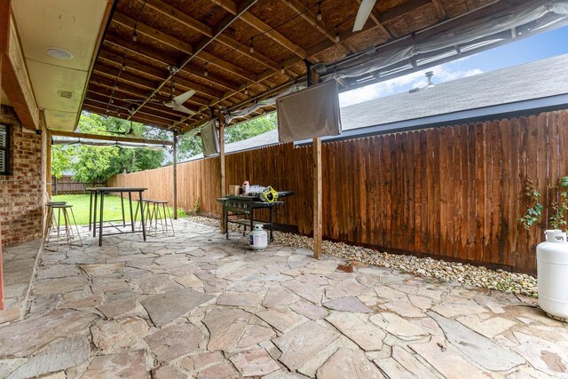 unfurnished bedroom with high vaulted ceiling, baseboards, wood finished floors, a skylight, and ensuite bath