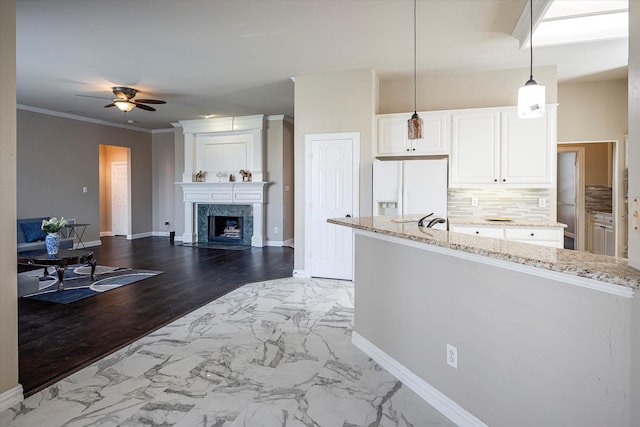 3704 Southport Dr, Plano, TX 75025 - kitchen featuring white fridge with ice dispenser, a ceiling fan, light stone counters, marble finish flooring, and a premium fireplace