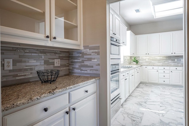 3704 Southport Dr, Plano, TX 75025 - kitchen with stainless steel oven, light marble finish floors, tasteful backsplash, light stone countertops, and a warming drawer