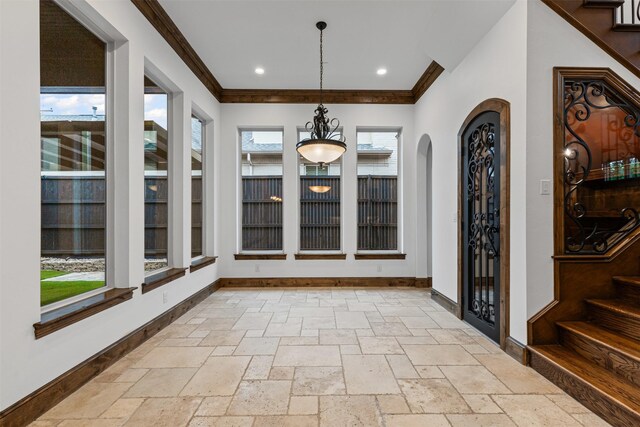 unfurnished dining area with crown molding, baseboards, stairs, stone tile floors, and recessed lighting