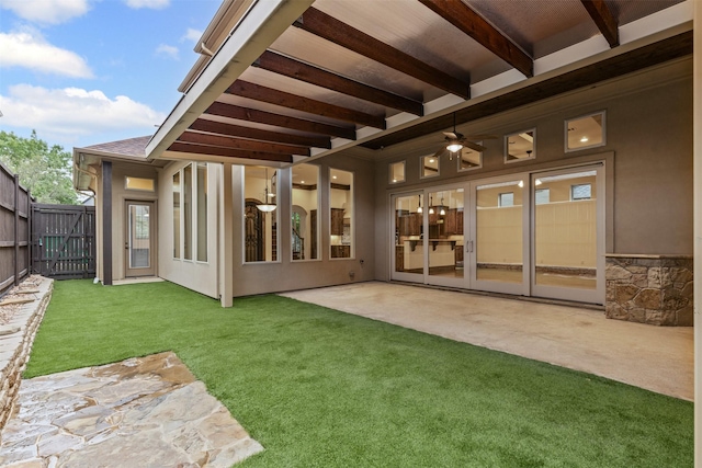 back of house with a patio, ceiling fan, roof with shingles, and stucco siding