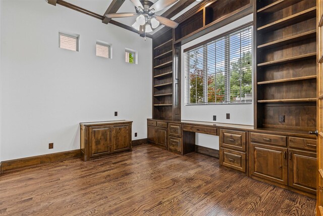 unfurnished office featuring built in study area, ceiling fan, dark wood-style flooring, and baseboards