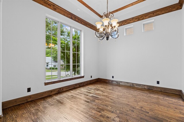 unfurnished room featuring wood finished floors, a chandelier, and baseboards