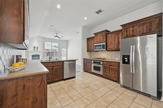 2691 Waterdance Dr, Little Elm, TX 75068 - kitchen featuring appliances with stainless steel finishes, a sink, backsplash, a ceiling fan, and light tile patterned floors
