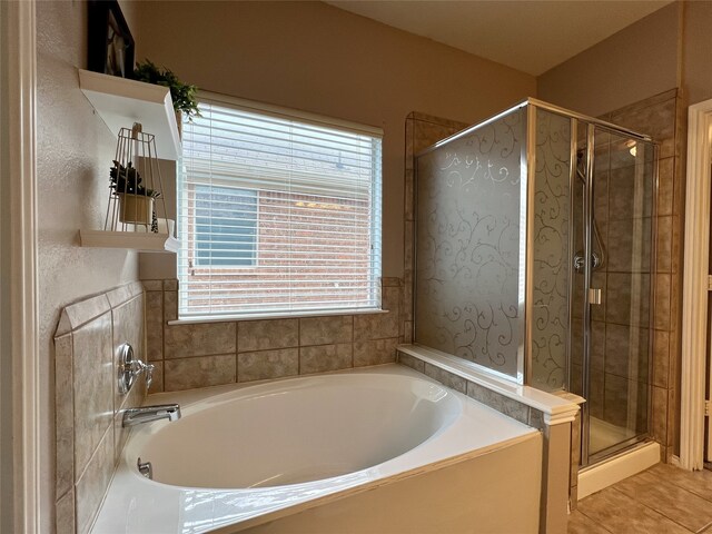bathroom with a shower stall, a garden tub, and tile patterned floors