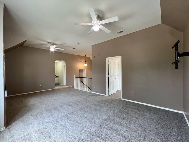 spare room featuring a ceiling fan, arched walkways, carpet flooring, and baseboards