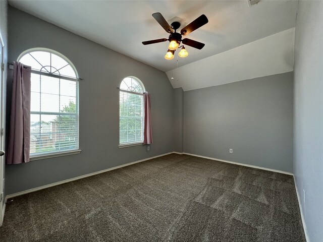 unfurnished room with dark colored carpet, ceiling fan, baseboards, and lofted ceiling