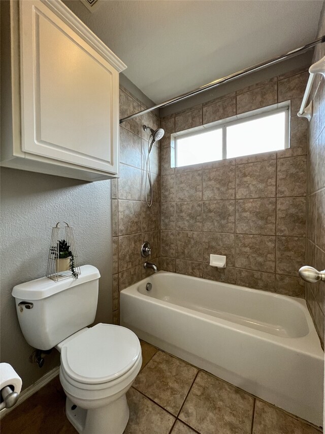 bathroom with toilet, tile patterned floors, and shower / bathtub combination