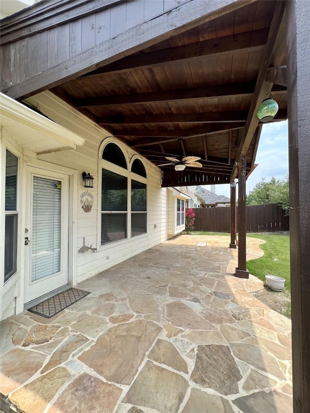 view of patio with fence and a ceiling fan