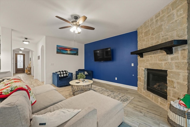 2643 Perdenales Dr, Royse City, TX 75189 - living room with a ceiling fan, arched walkways, a fireplace, wood finished floors, and baseboards