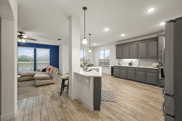 2643 Perdenales Dr, Royse City, TX 75189 - kitchen featuring appliances with stainless steel finishes, a sink, gray cabinetry, open floor plan, and light wood-type flooring