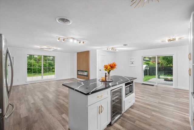 kitchen featuring wine cooler, appliances with stainless steel finishes, open floor plan, and healthy amount of natural light