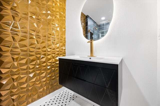 full bath featuring a tile shower and vanity