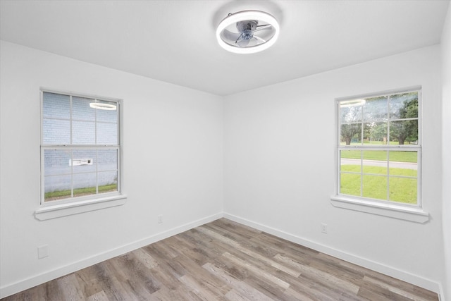 empty room with light wood-style floors, baseboards, and ceiling fan