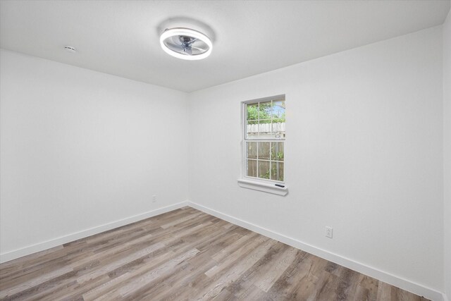 unfurnished room featuring light wood finished floors, ceiling fan, and baseboards