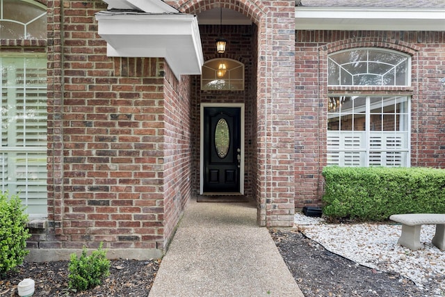 doorway to property featuring brick siding
